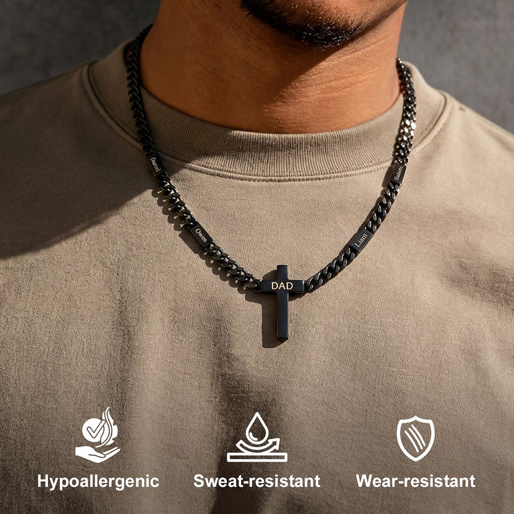 Person wearing a black custom name chain necklace with a cross pendant, set against a neutral background.