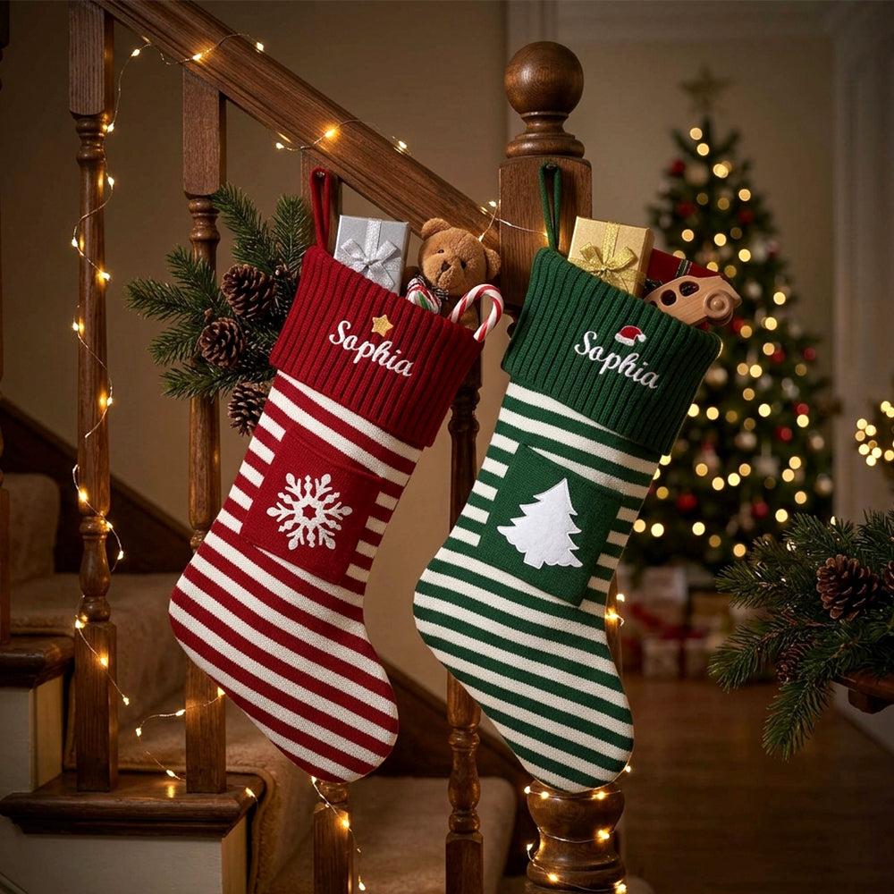 Two personalized Christmas stockings hang on a wooden staircase railing in a decorated living room. 