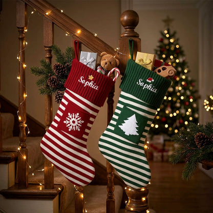 Two personalized Christmas stockings hang on a wooden staircase railing in a decorated living room. 