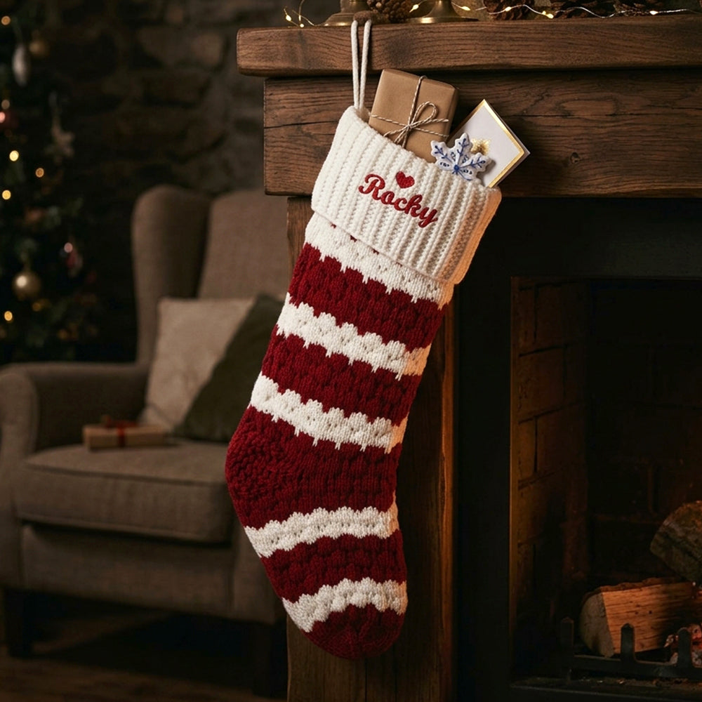 A knitted Christmas stocking with red and white stripes hangs from a rustic wooden mantel. 