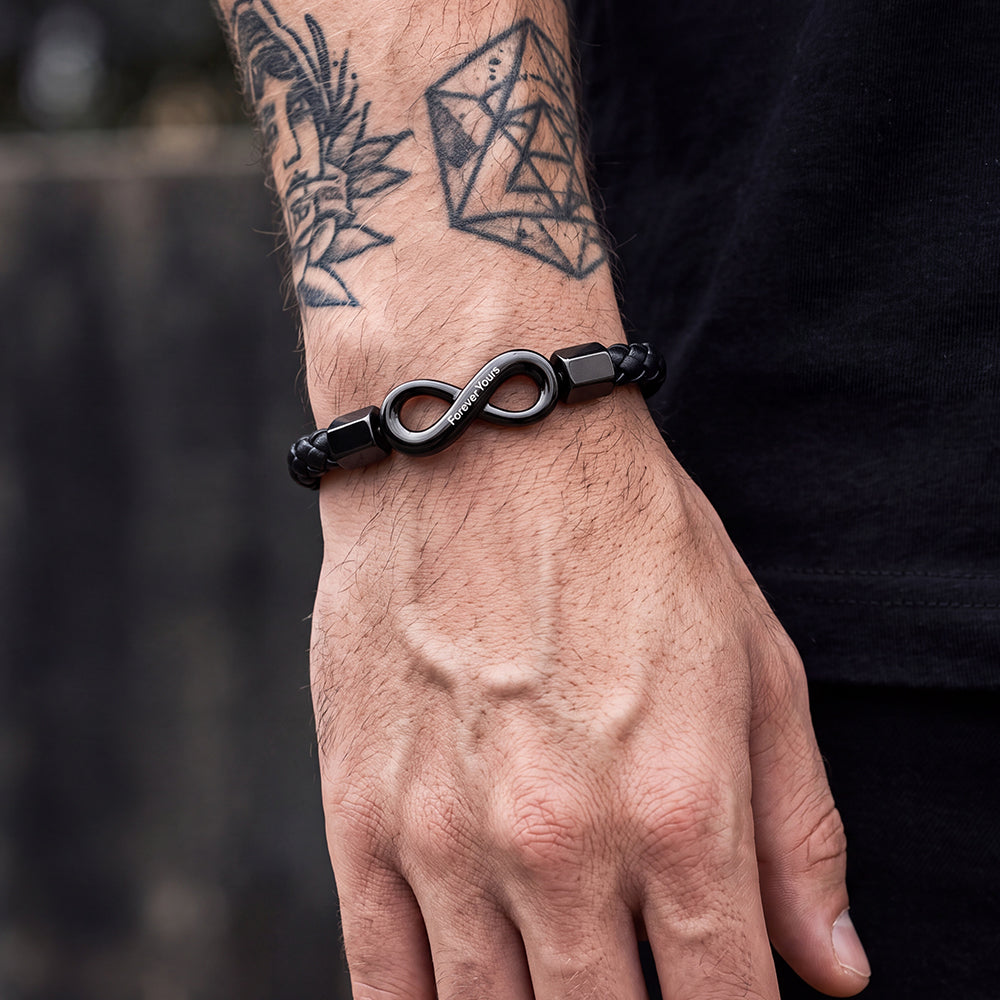 Close-up of infinity knot and custom engraving on braided leather wristband, detailed personalized bracelet on wrist