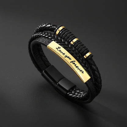 A black braided leather bracelet with a polished gold-plated ID bar engraved with 'Love you forever'.