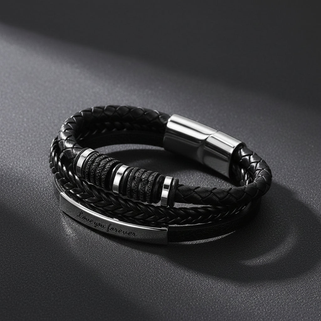 A black braided leather bracelet with a silver-toned metal clasp and a polished bar engraved with 'Love you forever'.