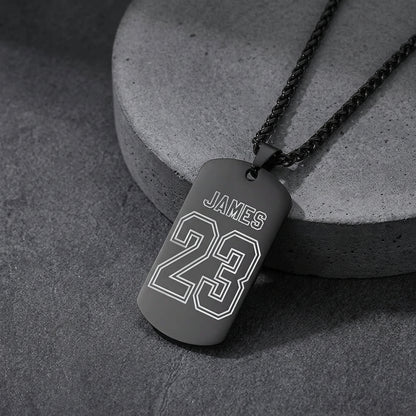 A black dog tag necklace engraved with the name and the number.