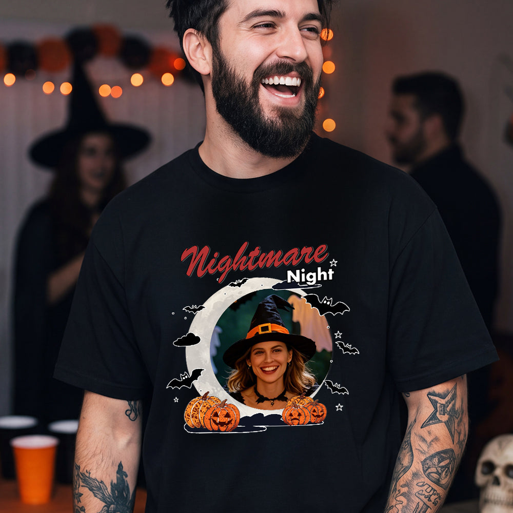 A man wearing a black graphic t-shirt with a 'Nightmare Night' Halloween design featuring pumpkins.