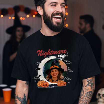 A man wearing a black graphic t-shirt with a 'Nightmare Night' Halloween design featuring pumpkins.