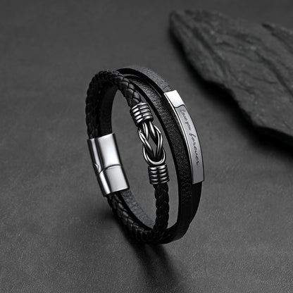 Close-up of infinity knot design and custom engraving on multi-layer leather bracelet
