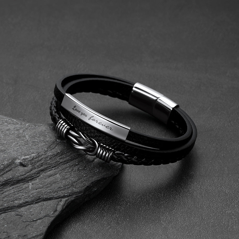 Close-up of infinity knot design and custom engraving on multi-layer leather bracelet
