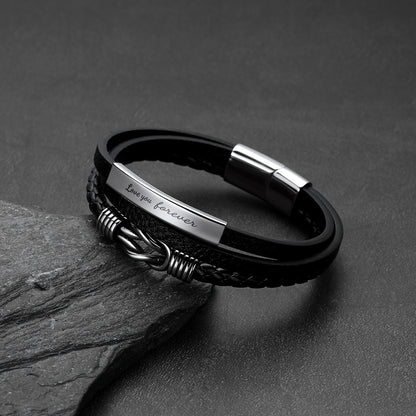 Close-up of infinity knot design and custom engraving on multi-layer leather bracelet