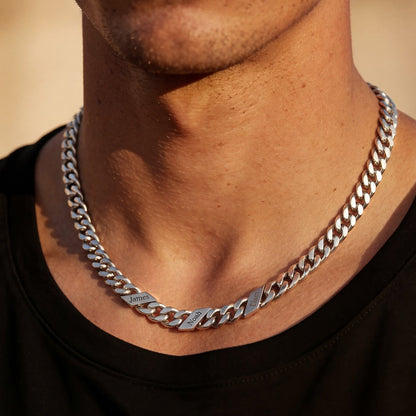 Man wearing a silver name chain necklace with a blurred background