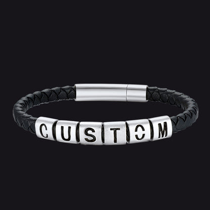 Black leather bracelet with silver beads spelling 'CUSTOM' on a black background