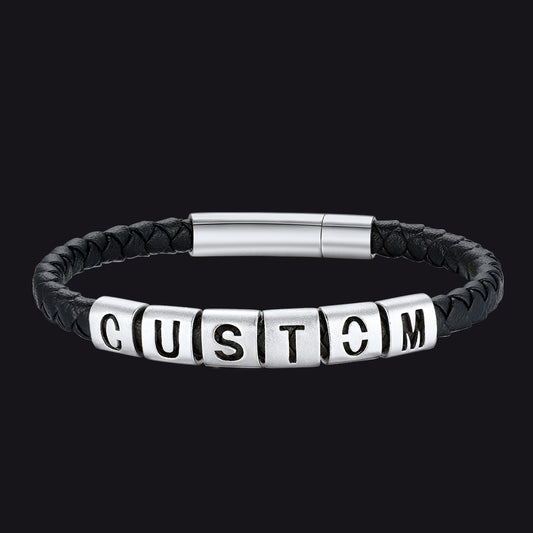 Black leather bracelet with silver beads spelling 'CUSTOM' on a black backgroundimg