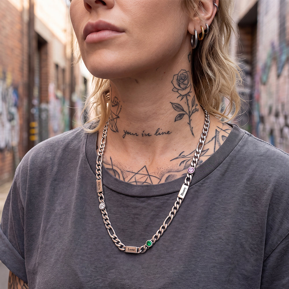 A close-up of a woman wearing a personalized silver-toned birthstone chain necklace.