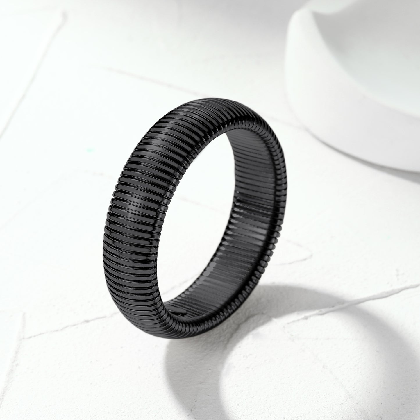 Black woven ring on a white fabric background