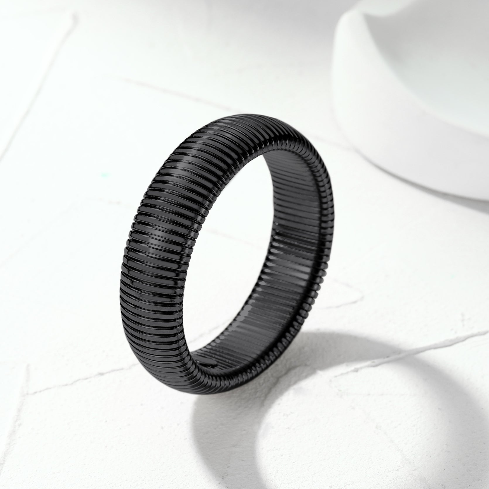 Black woven ring on a white fabric background
