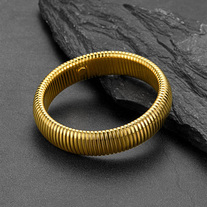 Gold bracelet on a dark stone surface