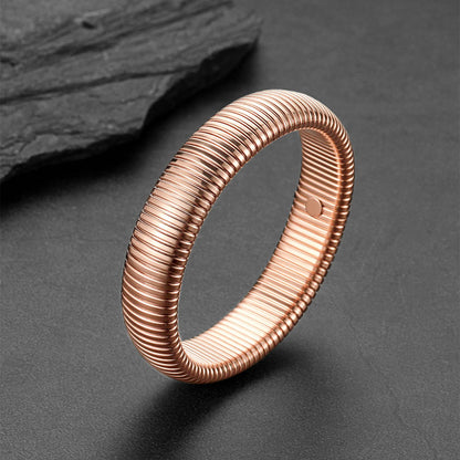 Rose gold ring with ribbed texture on a dark gray background