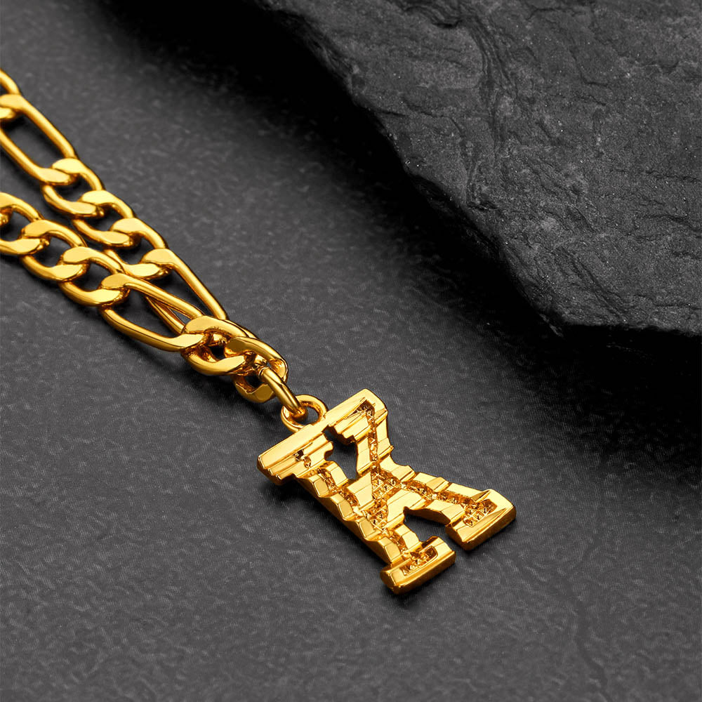 Gold chain with a pendant on a dark textured surface