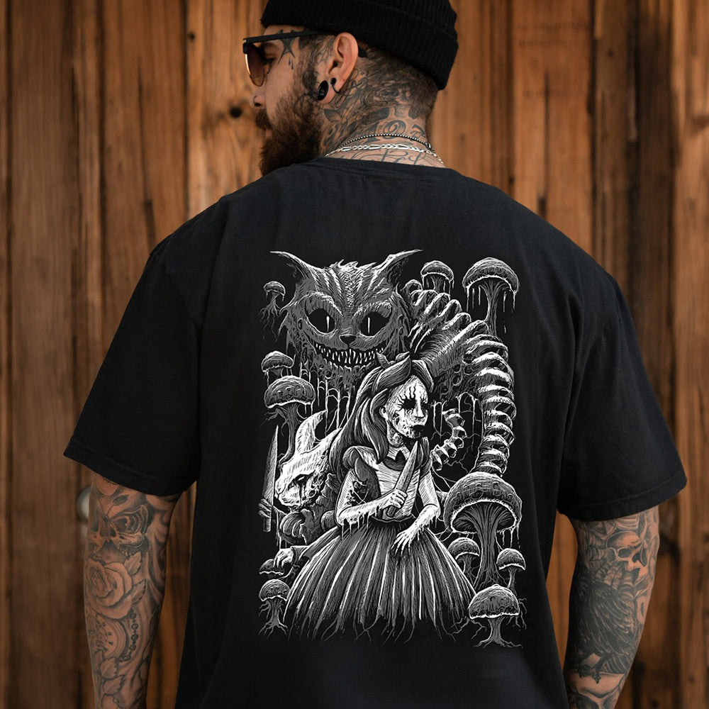 A man viewed from behind wearing a black t-shirt with a large white graphic print of Alice in Wonderland characters (the Cheshire Cat and a skeleton figure) on the back, set against a wooden plank wall.