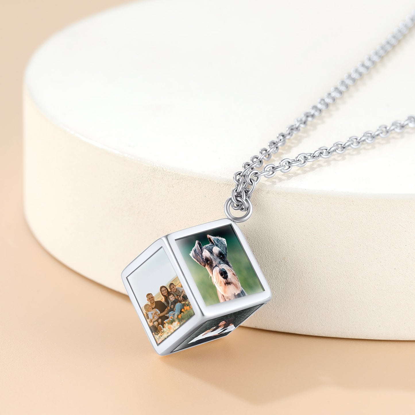 Cube-shaped necklace with embedded photos on a beige background