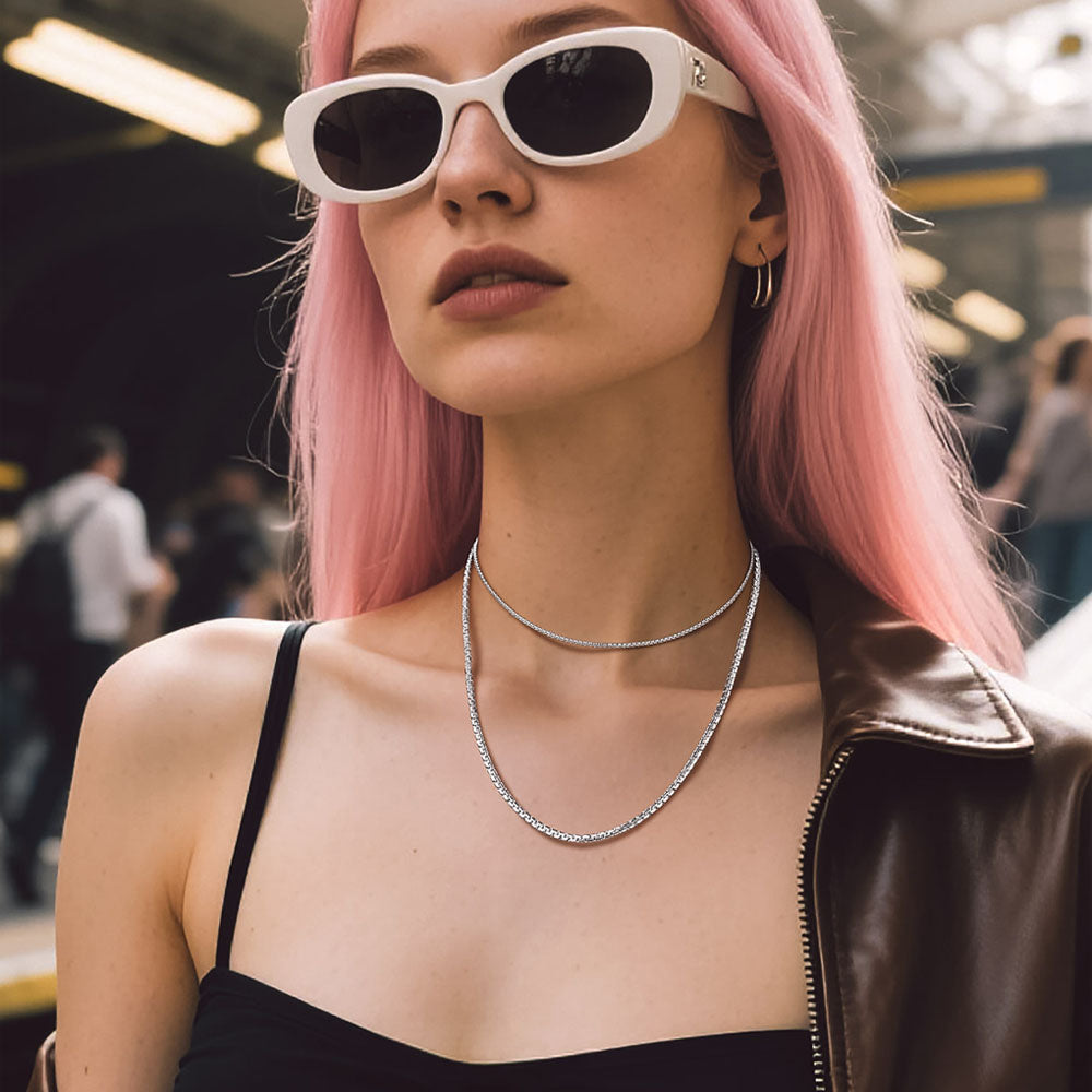 Female model styling layered steel flat box chains for modern streetwear