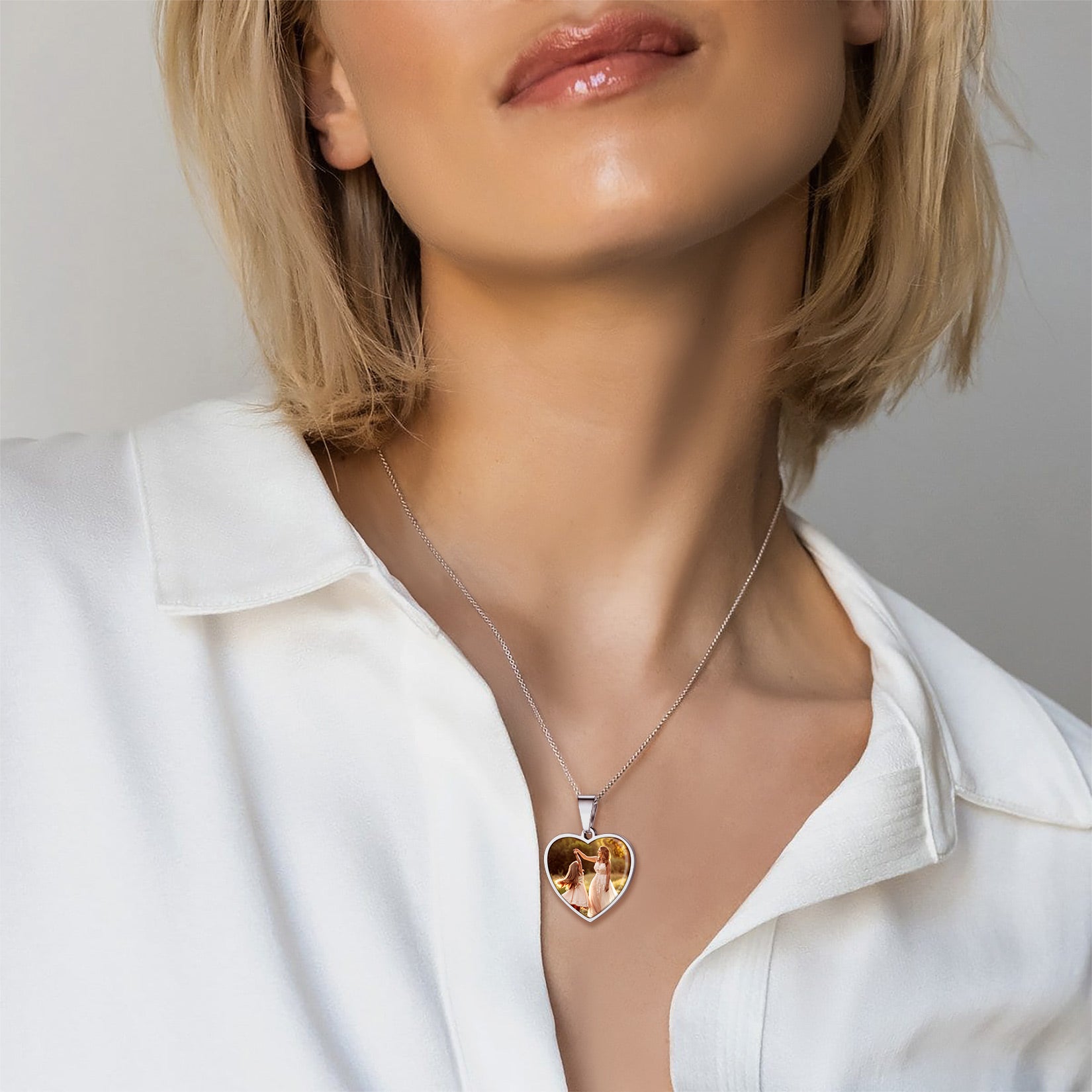 Heart-shaped necklace worn by a person with a plain background
