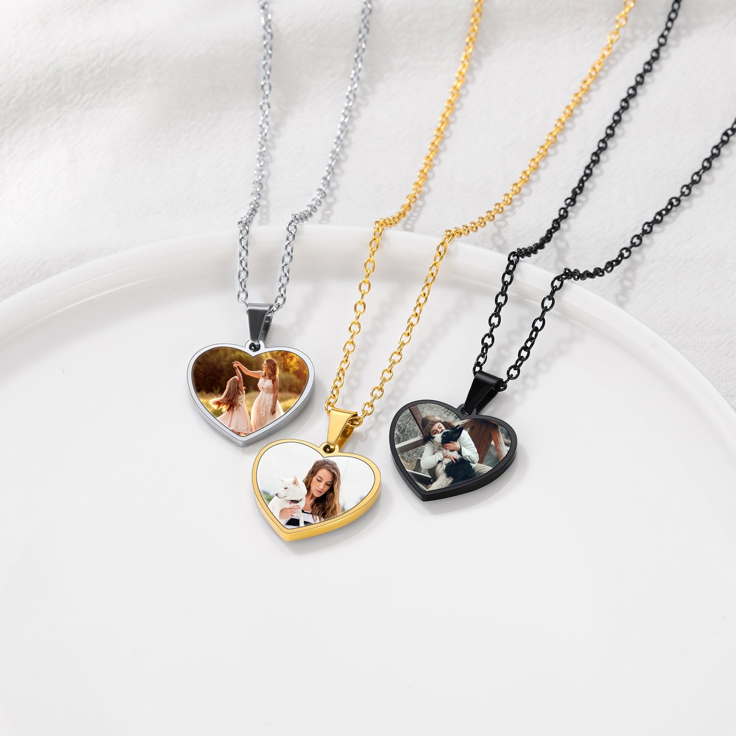 Four heart-shaped photo pendants on necklaces of different colors.