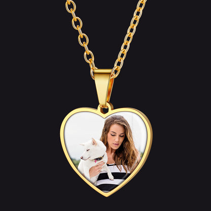 Gold heart-shaped necklace with a photo of a woman and a dog on a black background
