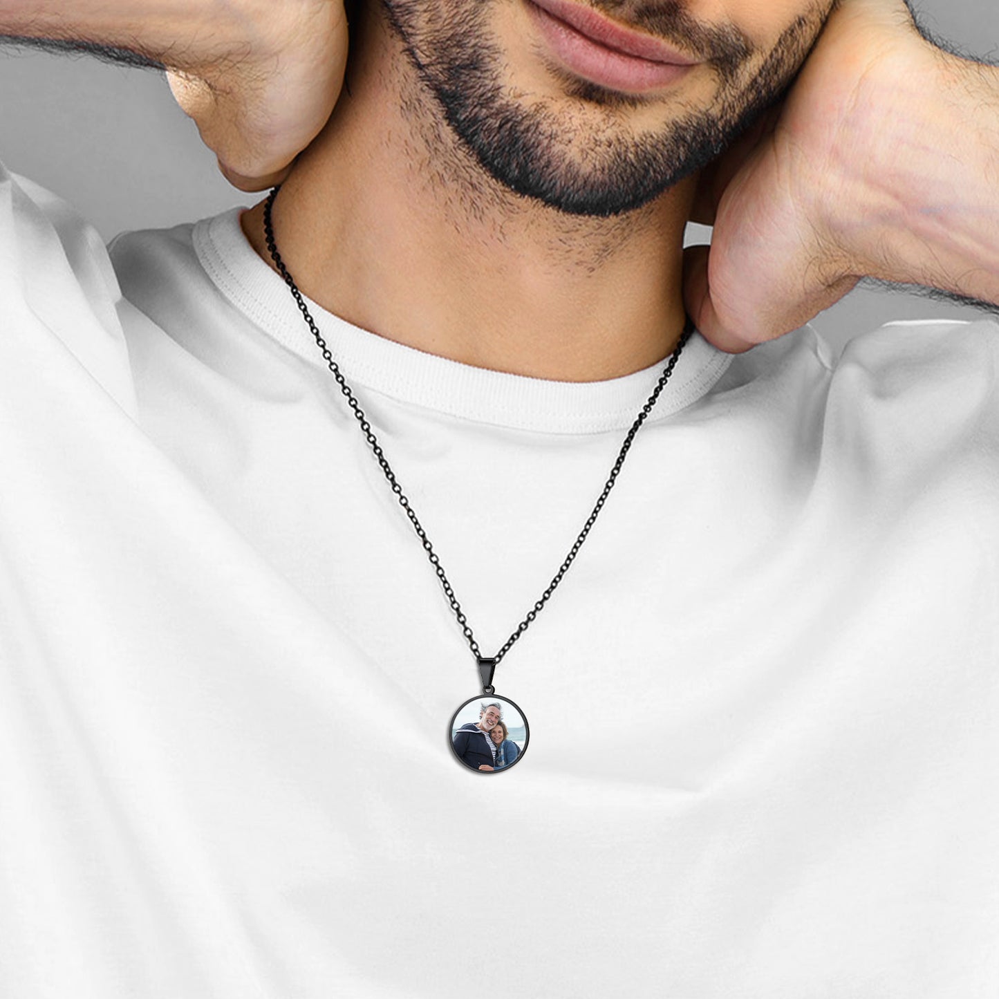 Man wearing a necklace with a pendant featuring a photo of a woman.