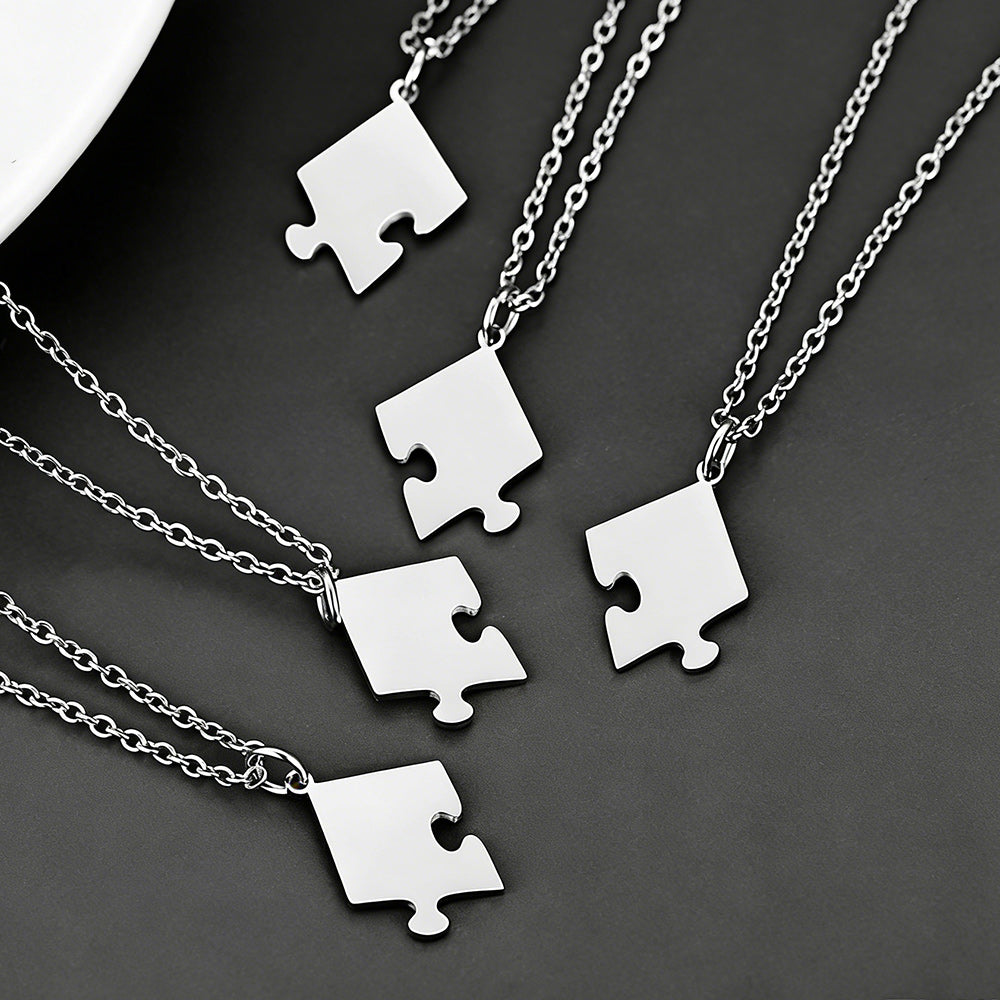 Silver puzzle piece necklaces on a dark background