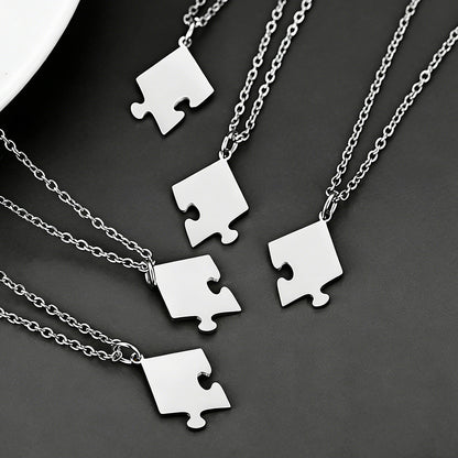 Silver puzzle piece necklaces on a dark background