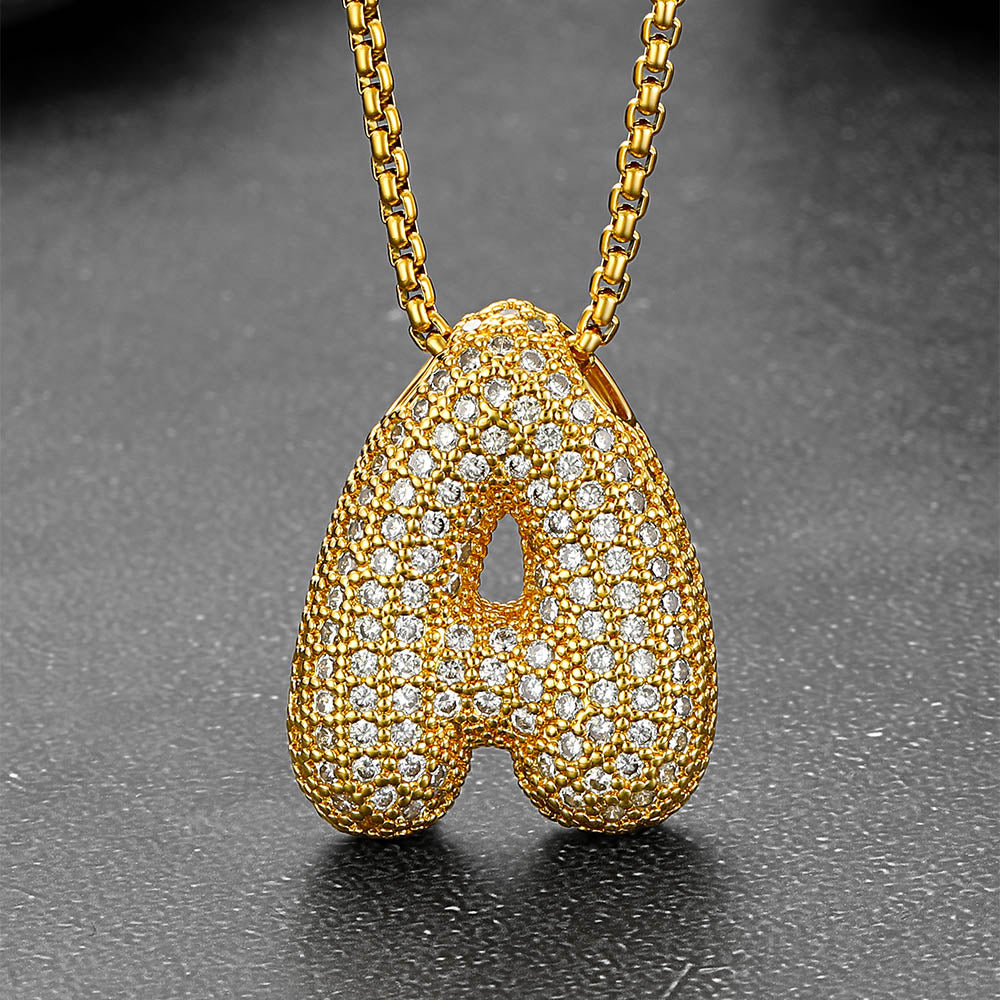 Gold letter necklaces arranged on white background
