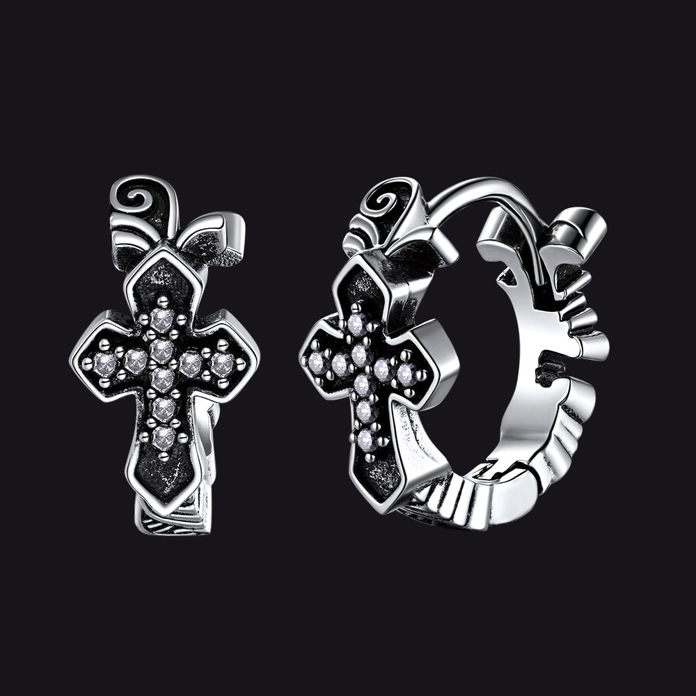 Silver cross-shaped earrings on a black background