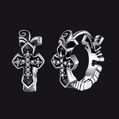 Silver cross-shaped earrings on a black background