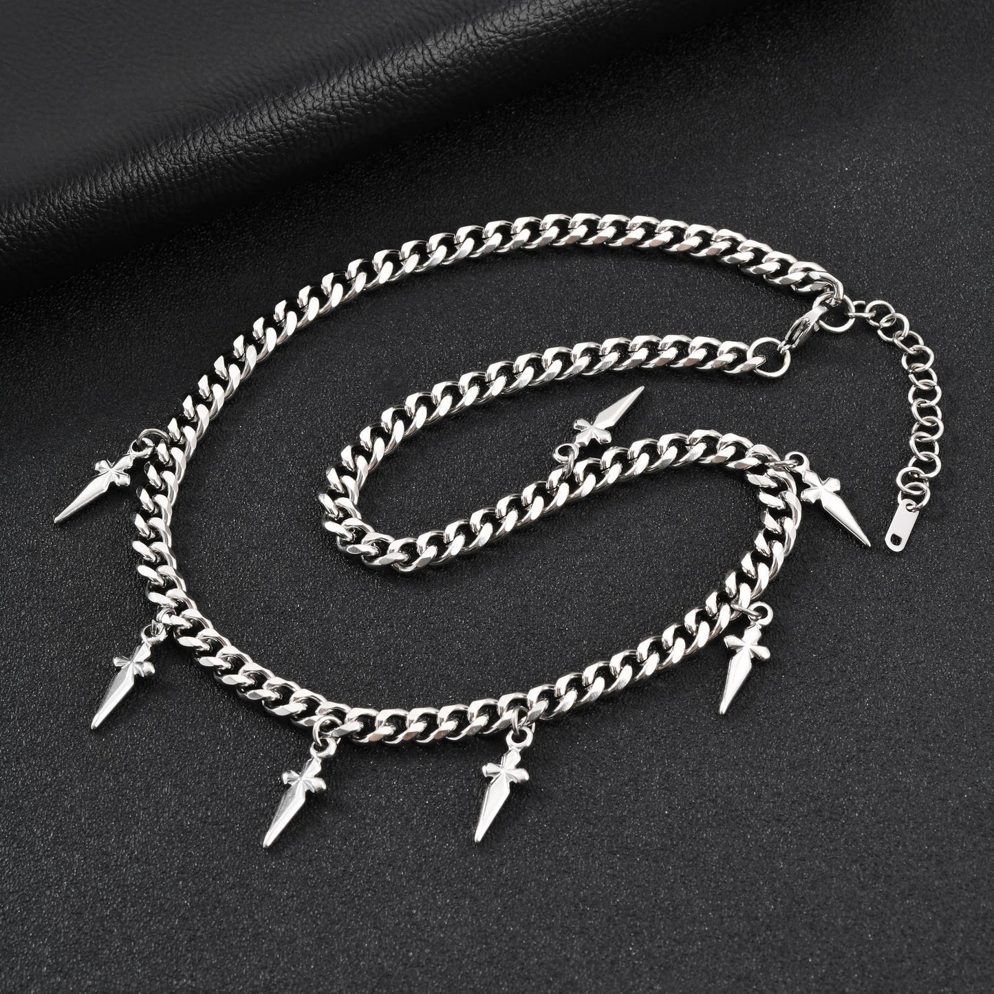 Silver chain anklets with spike charms on a dark surface