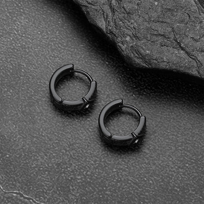 Black hoop earrings on a textured gray surface