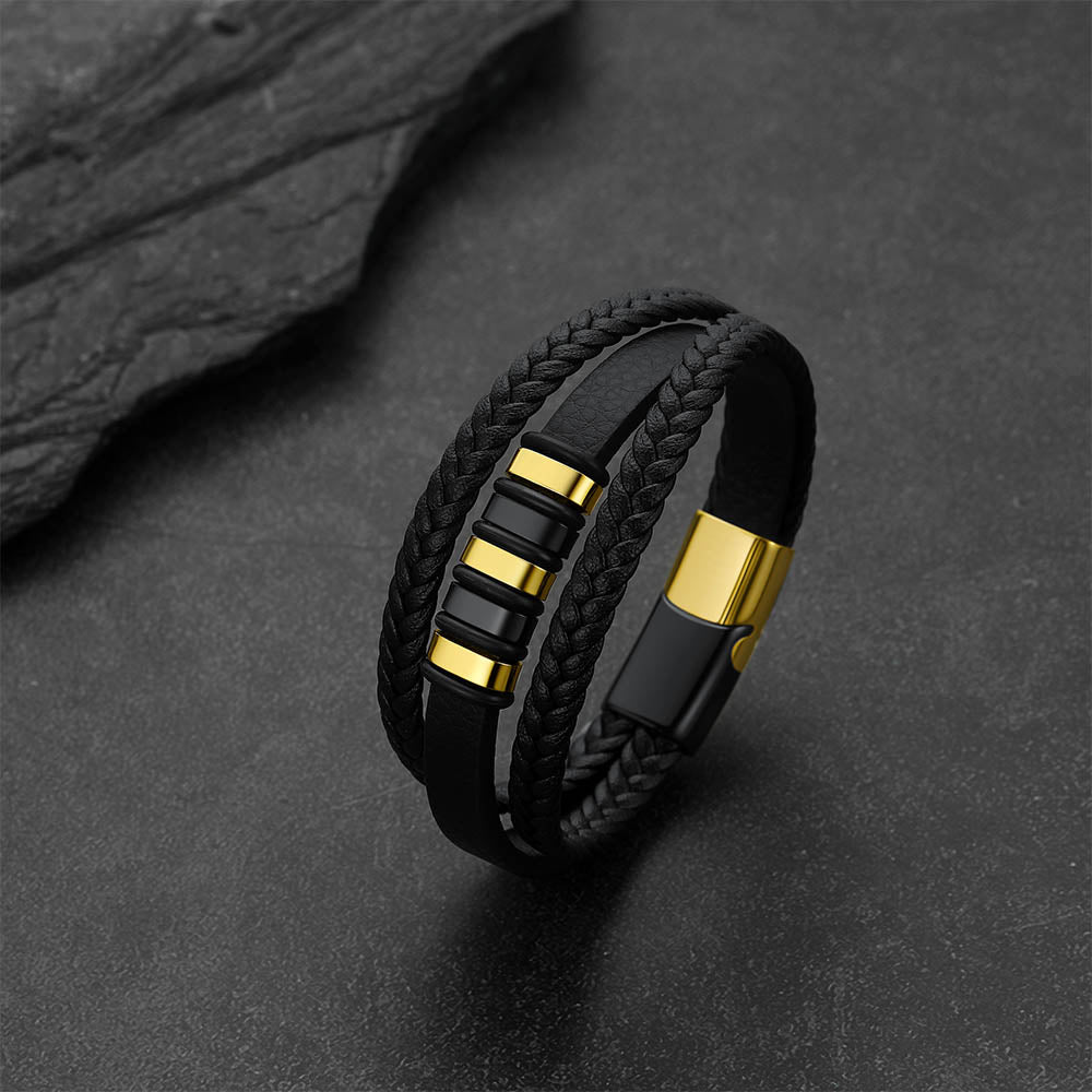 Gothic-style multi-layered leather bracelet against a dark gray rock background.