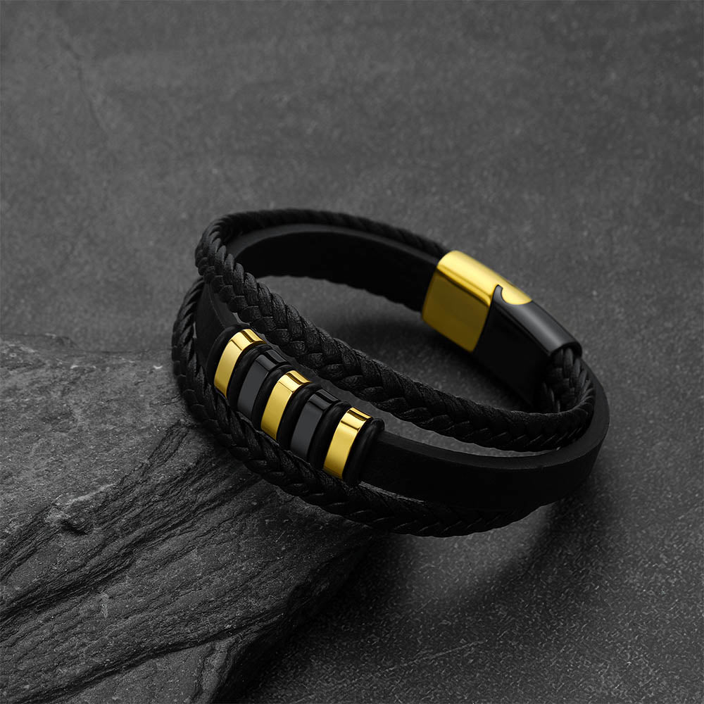 Gothic-style multi-layered leather bracelet against a dark gray rock background.