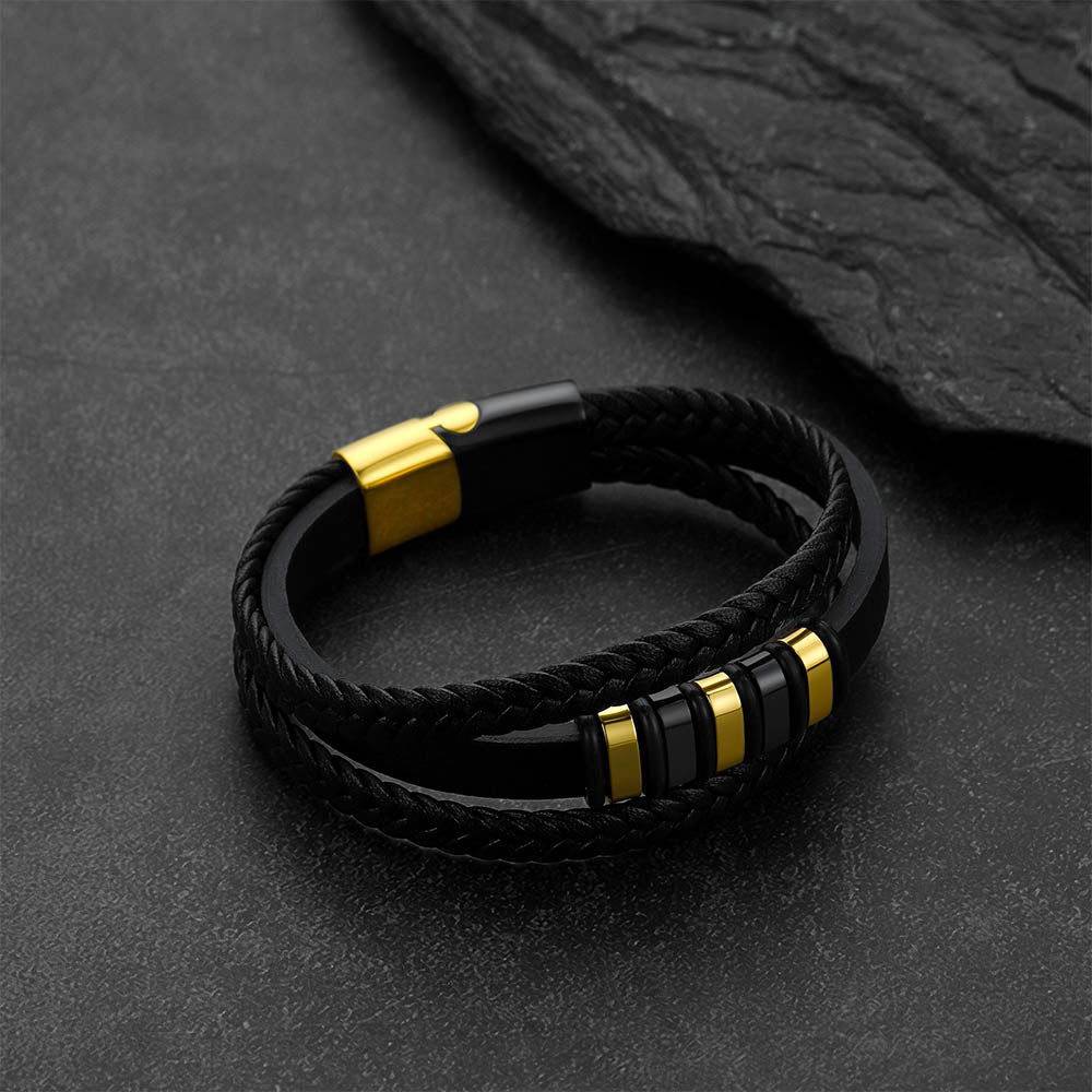 Gothic-style multi-layered leather bracelet against a dark gray rock background.