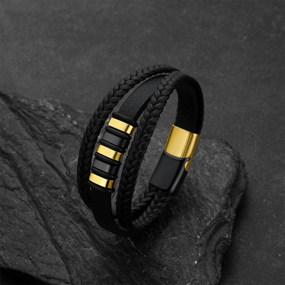 Gothic-style multi-layered leather bracelet against a dark gray rock background.