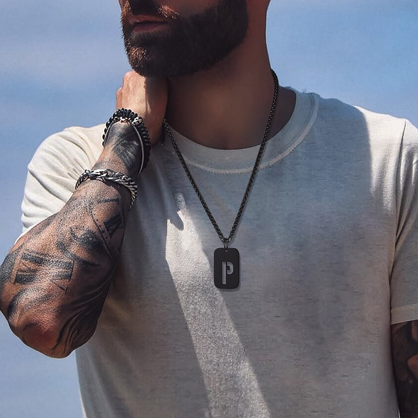 Man wearing a dog tag pendant necklace with the letter P
