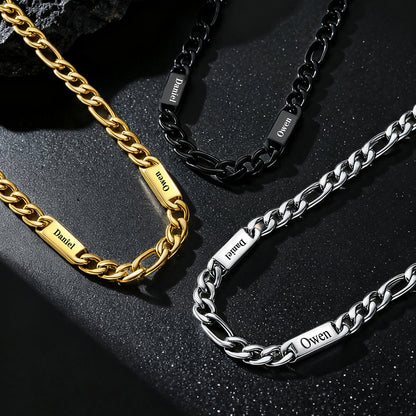 Three chain necklaces in gold, black, and silver on a dark surface.