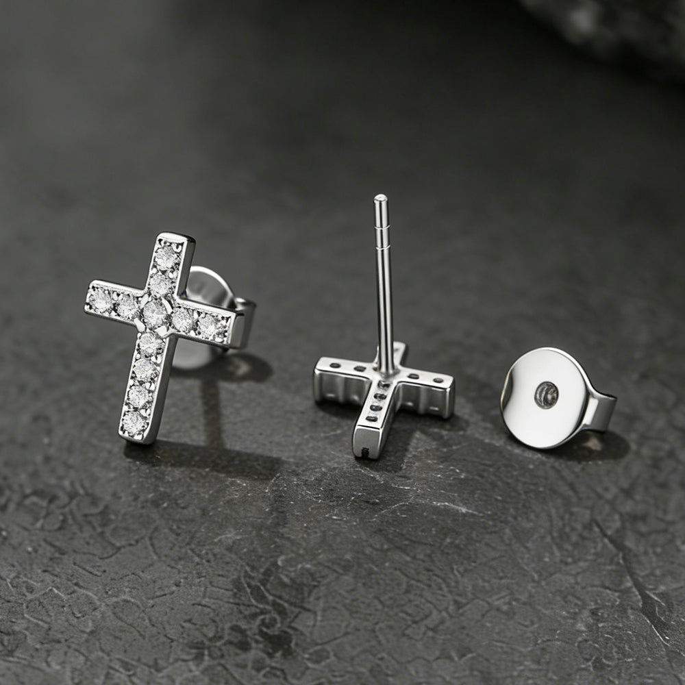 Three pairs of silver earrings on a textured dark surface