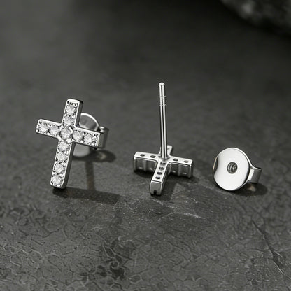 Three pairs of silver earrings on a textured dark surface