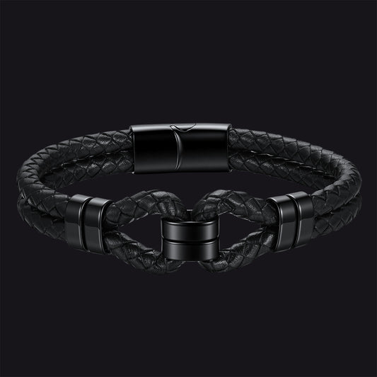 Black braided leather bracelet with a twisted knot design and matte black metal accents, shown on a dark background.img