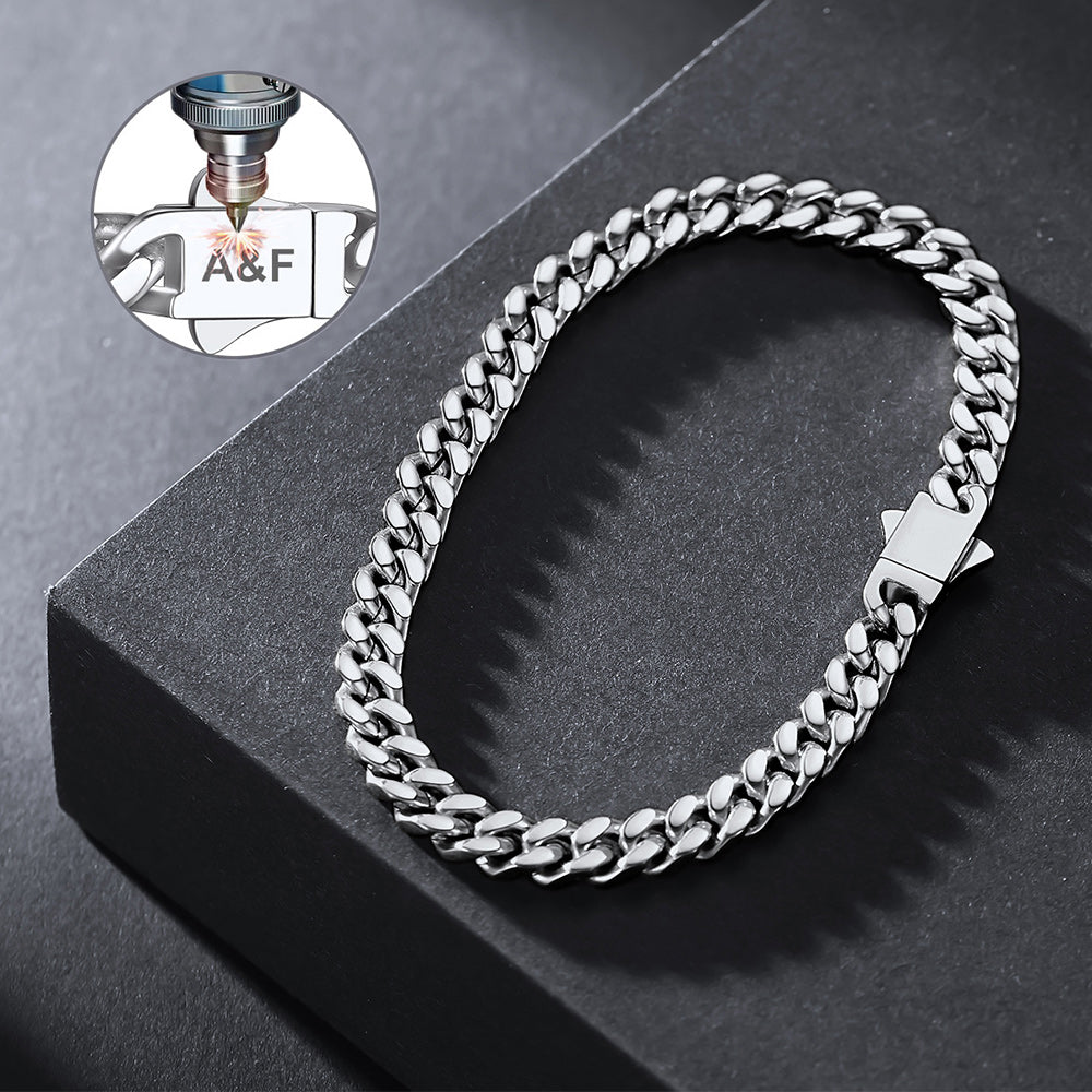 Silver chain bracelet on a dark surface with a close-up of a bottle label in the corner.