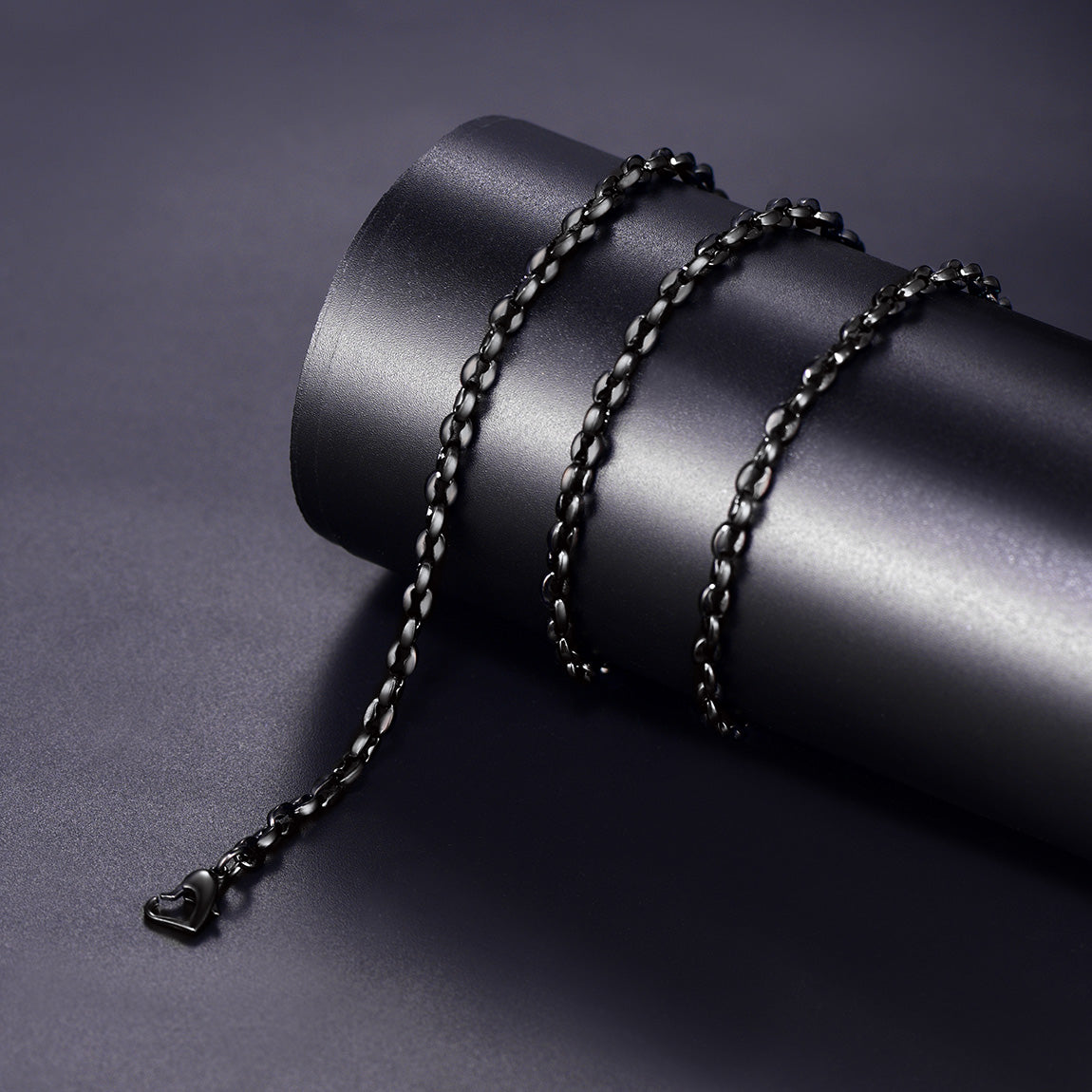 Black chain necklace on a dark cylindrical object