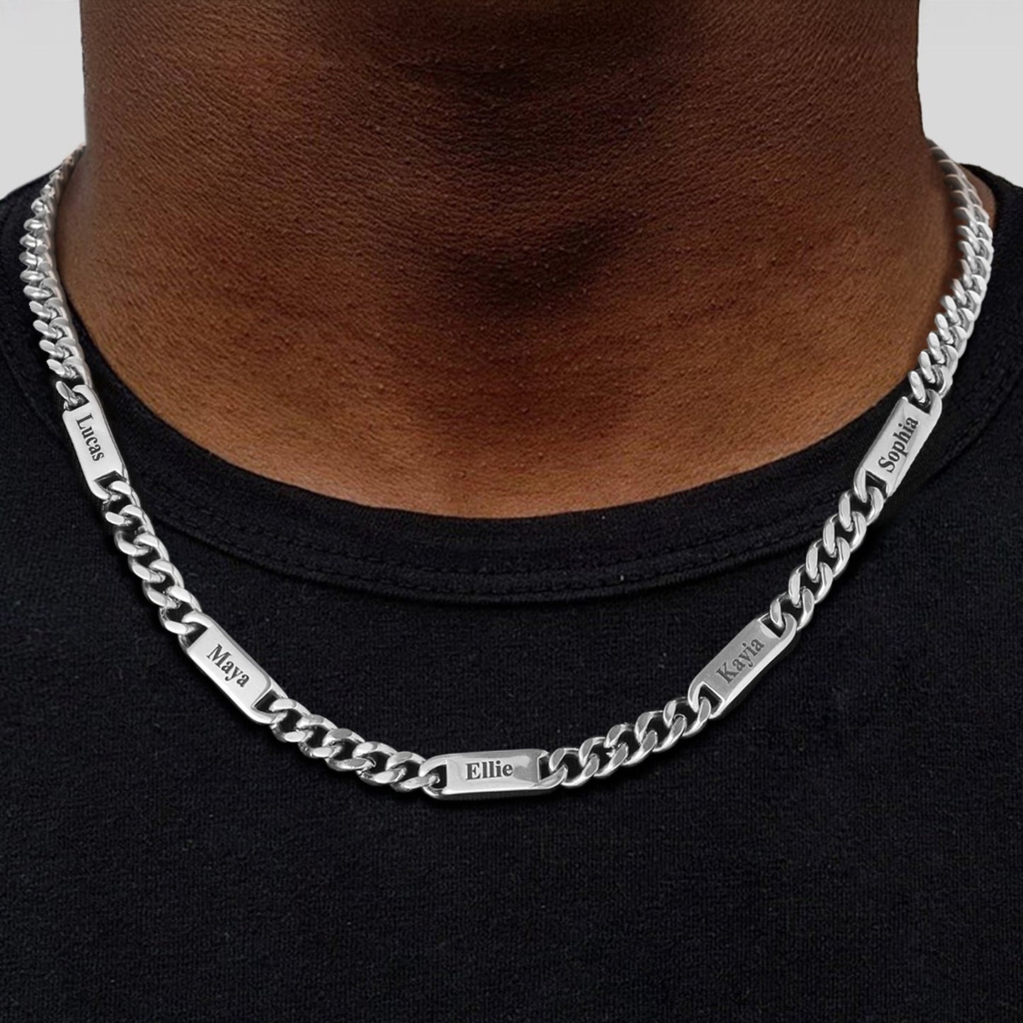 Silver cuban chain name link necklace with engraved names on a black shirt