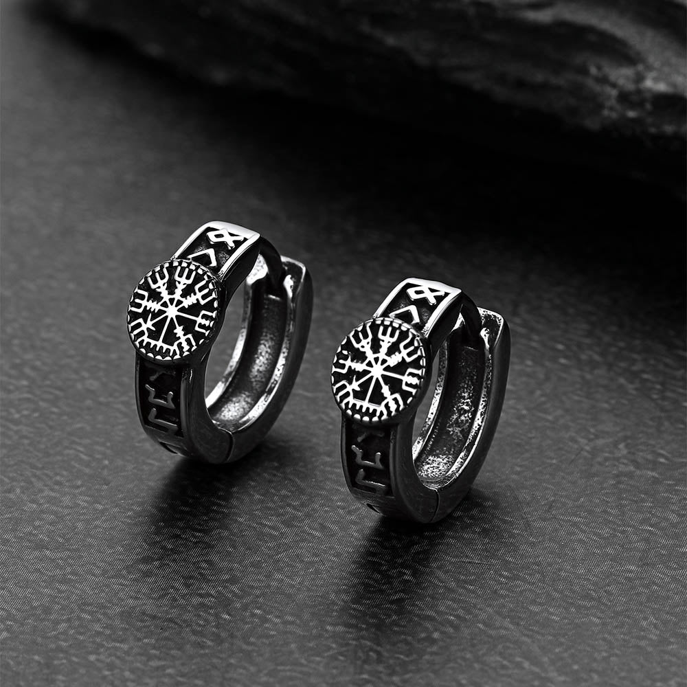 Pair of black hoop earrings with Norse Viking Compass on a dark surface