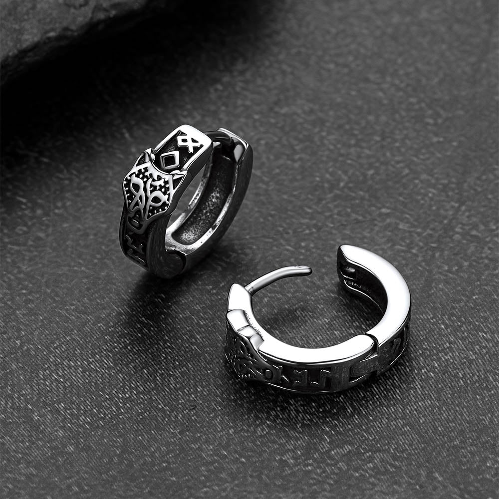 Pair of silver hoop earrings on a dark textured surface